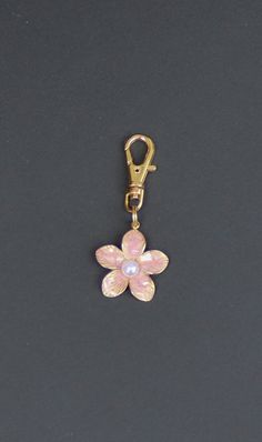 **THE COLOR OF THIS FLOWER IS LIGHT PINK, BUT MAY HAVE SLIGHTLY DIFFERENT TONES ON SOME COMPUTER SCREENS. This very sweet, light pink flower makes an adorable little zipper charm to use on a jacket, backpack, cosmetic bag, purse, planner, computer bag, or wallet.  The flower petals are different hues of pink, with a somewhat glossy finish. A little faux pearl sits in the center of the flower. Nice little gift for the flower lover or gardener. Charm is one-sided, gold-tone. Lobster clasp  9mm x 2 Cheap Pink Metal Charms, Pink Charms, Pink Keychain, Pink Charm, Light Pink Flowers, Handbag Essentials, Car Goals, Computer Bag, Zipper Charms