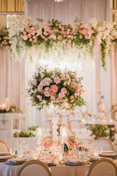 a table with flowers and candles is set up for a wedding reception in the ballroom