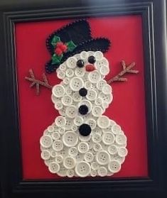 a snowman made out of buttons in a black frame on a red wall,