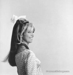 black and white photograph of a woman with long hair wearing a bow in her hair