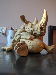 a statue of a rhinoceros sitting on top of a table