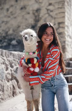 a woman is holding a llama in her arms