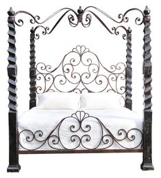 an iron bed frame with white sheets and pillows