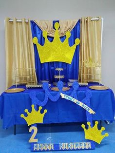 a blue and gold birthday table with two crowns on it