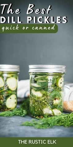 two jars filled with pickles and cucumbers on top of a blue surface