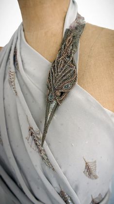 a close up of a woman wearing a white dress with an elaborate necklace on her neck