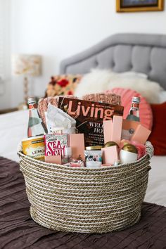 a basket filled with various items on top of a bed next to a gray headboard