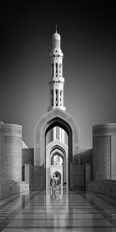 a black and white photo of an entrance to a building with a clock tower in the background