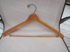 a wooden coat hanger sitting on top of a chair