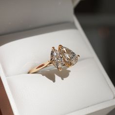 two pear shaped diamond engagement rings in a box