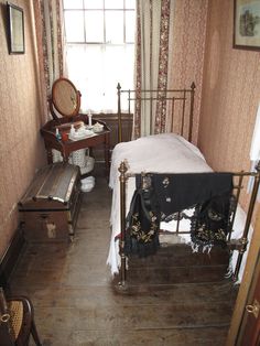 an old fashioned bedroom with a bed and dresser