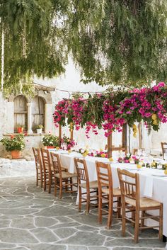 an outdoor dining area with tables, chairs and flowers on the tablecloths are arranged in rows