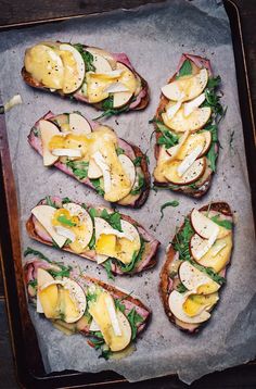 several sandwiches are arranged on a baking sheet