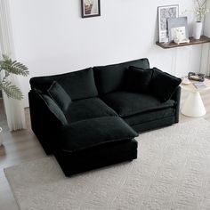 a black couch sitting on top of a white rug