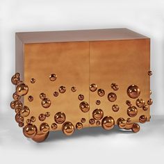 a golden cabinet with lots of bubbles on it