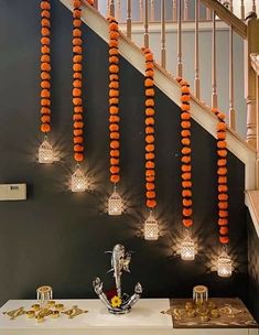 some lights that are hanging from the side of a stair case with orange balls on it