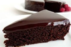 a piece of chocolate cake on a plate with raspberries