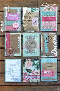 many different types of cards and envelopes on a wooden table with some tags attached to them