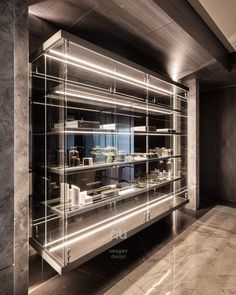 a glass display case in the middle of a room with marble flooring and walls