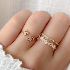 a woman's hand with three rings on top of it, and one ring in the middle