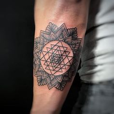 a man's arm with a tattoo on it that has a geometric design in the middle