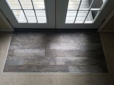 an overhead view of a door with two glass panels on the side and a tile floor