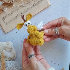 a person holding a small stuffed animal in their hands with musical notes on the wall behind them