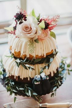 a three tiered cake with white frosting and flowers on top