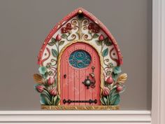 an elaborately decorated clock with a pink door