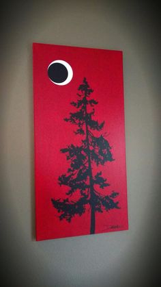 a red painting with a black tree on it