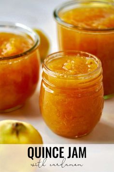 two jars filled with orange jam next to an apple