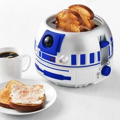 a toaster that is sitting on a table next to a plate with some bread