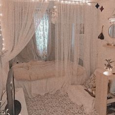 a bedroom decorated in white with lights on the ceiling and curtains hanging over the bed