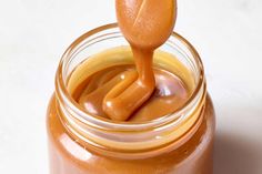 a jar filled with peanut butter and a wooden spoon