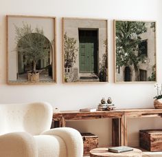 three framed pictures hang on the wall above a white chair and coffee table in a living room