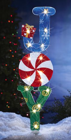 a lighted christmas decoration on top of a snow covered ground