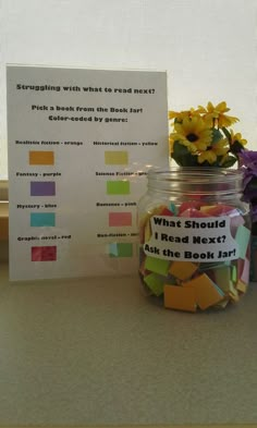 a jar filled with colorful sticky notes next to a sign that says what should i read next?