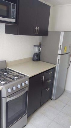 a kitchen with black cabinets and silver appliances