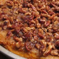 a close up of a pie with pecans on it's crusty crust