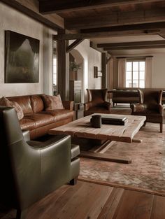 a living room with leather furniture and wood flooring