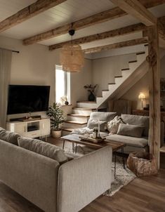 a living room filled with furniture and a flat screen tv on top of a wooden table