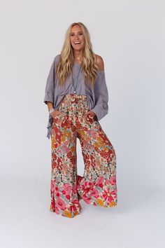 Groovy vibes only while wearing the Groovy Gardens Wide Leg Pant! Get ready for plenty of compliments while wearing these because they feature: Lightweight and flowy woven fabric with an eye - catching floral print throughout Loose and flowy wide leg silhouette High - rise smocked elastic waistline for a comfy fit Convenient side pockets Make a comfy statement in these by pairing with: Sophie Crochet Lace Bralette, Scoop Neck Bralette Tee, Kylie Studded Sandal *Due to lighting and differences in High-waisted Floral Wide Leg Pants For Spring, Hippie Boho Print Vacation Bottoms, Spring Floral Print High-waisted Wide Leg Pants, Spring Floral Print Wide Leg Pants, Summer Printed Pants For Loungewear, Summer Printed Loungewear Pants, Spring Floral Print Wide Leg Bottoms, Bohemian Floral Print Beach Bottoms, Floral Print Flowy Skirt For Day Out