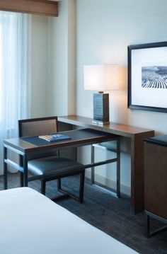 a hotel room with a desk and chair