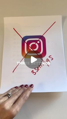 someone is holding up a piece of paper with the instagram logo on it in front of them