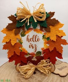 a cake decorated with autumn leaves on top of a wooden slice that says hello & 39