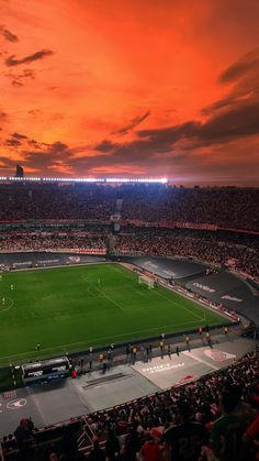 an empty soccer stadium at sunset with the sun going down