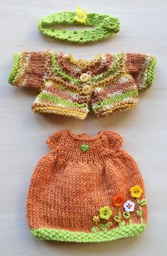 two knitted sweaters and hats on a table