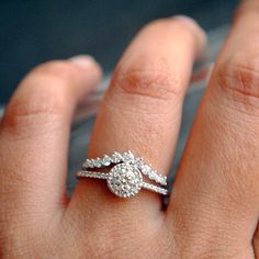 a close up of a person's hand with a diamond ring on their finger