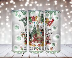 two cans with christmas themed labels on them sitting on a wooden table in front of lights