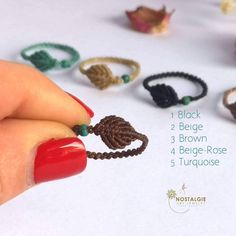 a woman's hand holding an assortment of beaded bracelets and ring sets